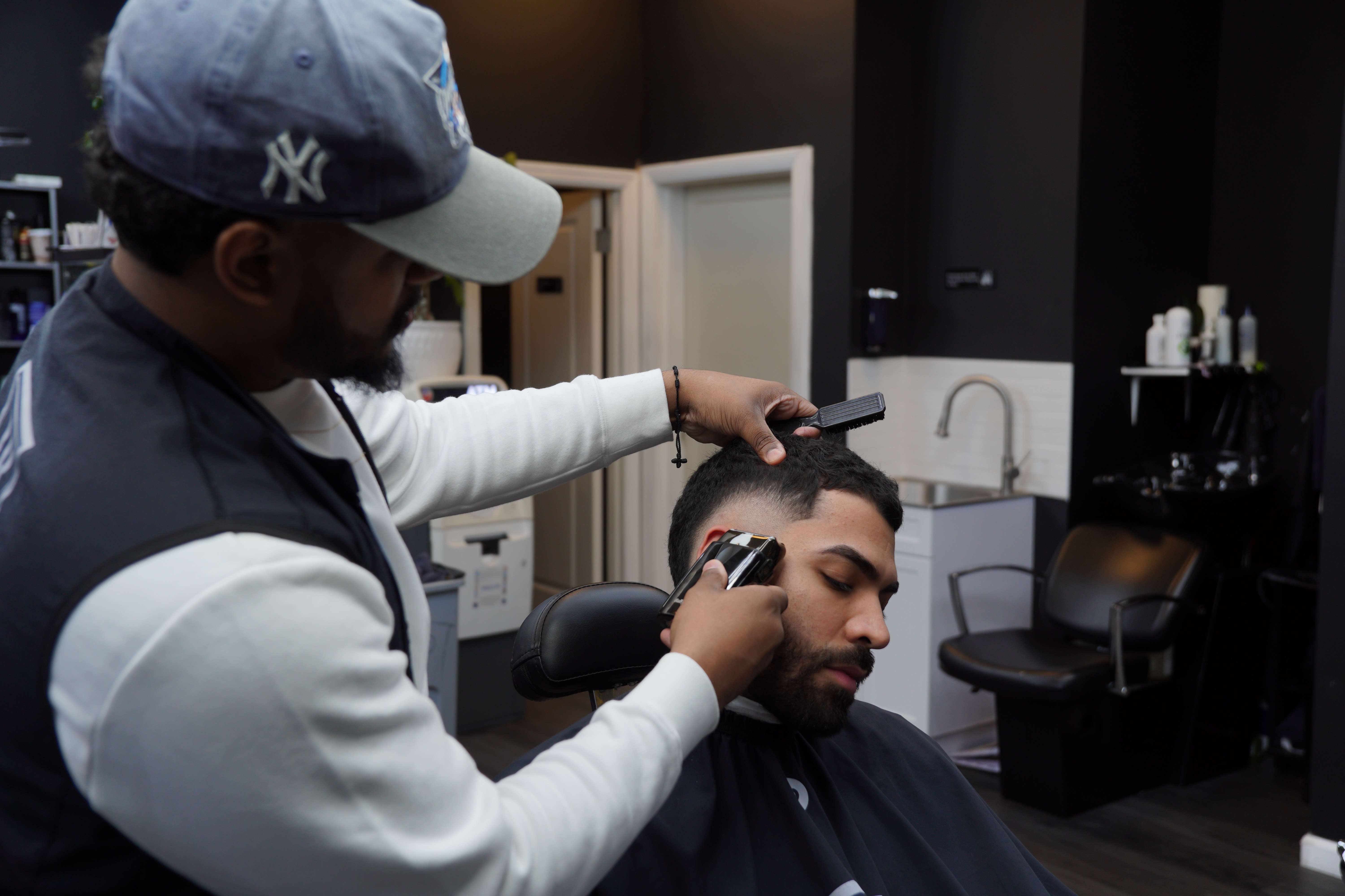 Rommell using clippers on client in modern barbershop